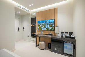 a bathroom with a desk with a tv on the wall at Padma Hotel in Vlorë