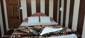 a bedroom with a bed with a head board at BAKSHI lodge in Pahalgām