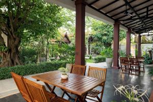 a wooden table and chairs on a patio at Moringa Tree Maison in Siem Reap
