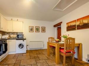 a kitchen with a table and chairs and a stove and a sink at 1 Bed in Penrith oc-90417 in Kirkoswald +13 photos