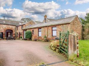 an old brick house with a gate in front of it at 1 Bed in Penrith oc-90417 in Kirkoswald