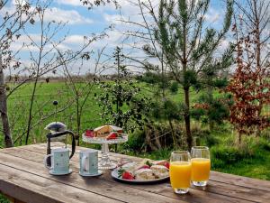 a table with a plate of food and glasses of orange juice at 2 Bed in Ormskirk oc-90263 in Barton