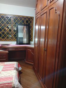 a bedroom with a bed and a wooden cabinet at Suite Sol I in Curitiba
