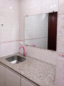 a bathroom with a sink and a mirror at Suite Sol I in Curitiba