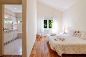 a white bedroom with a large bed and a bathroom at Villa Aqueduto in Póvoa de Varzim +54 photos