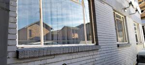 a window of a house with a reflection of a building at AMBROZIA Apartment-self catering-2bed2bath in Bloemfontein