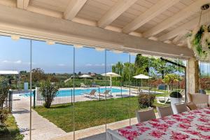 a dining room with a table and a view of a pool at Bardolino Golden Hill in Bardolino