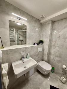 a white bathroom with a sink and a toilet at Stay In Centre in Brno +18 photos