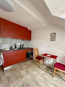 a kitchen with red cabinets and a table and chairs at Stay In Centre in Brno