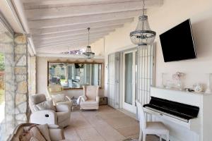 a living room with a piano and chairs at Bardolino Golden Hill in Bardolino