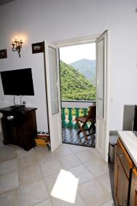 d'un salon avec une porte s'ouvrant sur un balcon. dans l'établissement Appartamento Carrerapiana, à Pigna