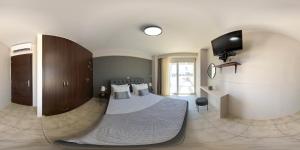 a bedroom with a bed and a flat screen tv at United Cretan Villas & Spa in Agia Marina Nea Kydonias +25 photos