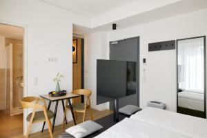a bedroom with a bed and a tv and a table at appartello - smarttime living Berlin in Berlin
