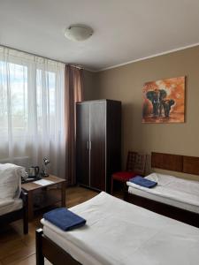 a hotel room with two beds and a cabinet at AtmosferA in Bydgoszcz