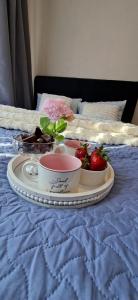 a tray with strawberries and a bowl on a bed at Rohu Apartment in Pärnu