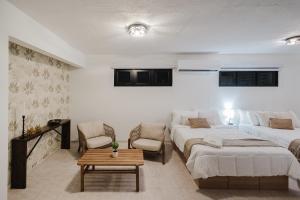 a bedroom with two beds and a couch and a table at 623 Boquerón Villas in Boqueron +26 photos