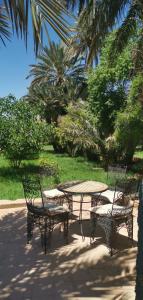 a table and two chairs and a table and a table and chairs at Écolodge OASIS Vallée du ZIZ Gîte DAR UL in Maarka