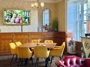 a dining room with a table and yellow chairs at The Lion Hotel in Builth Wells