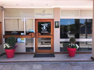 a front door of a hotel with two potted plants at Hotel Don Carlos in Villa Gesell