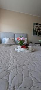 a white bed with a tray of flowers on it at Laine Apartment in Pärnu