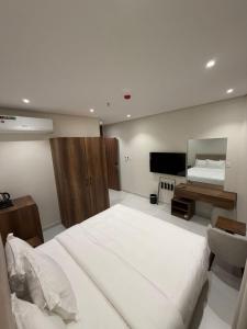 a bedroom with a large white bed and a television at توليب حتا 2 Tulip Hatta in Al Khobar