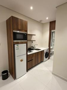 a kitchen with a white refrigerator and a sink at توليب حتا 2 Tulip Hatta in Al Khobar