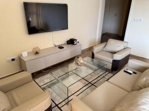 a living room with a couch and a tv at Appartements modernes, Wifi, TV - Yaoundé, Omnisports in Yaoundé