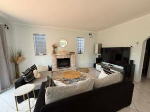 a living room with a couch and a fireplace at Casa Marianna-Luxury Riviera Retreat in Anavyssos +10 photos