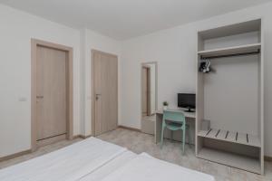 a white room with a bed and a desk at Park Hotel Faver in Tremosine Sul Garda