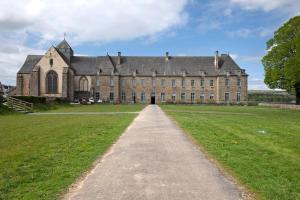 a large brick building with a long driveway at Mignonne en lisière de Brocéliande in Mauron