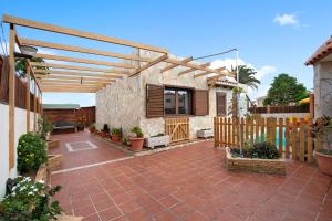 a patio with a wooden pergola and a fence at Las Casitas 28 in Corralejo
