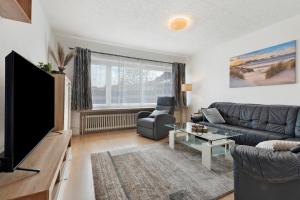 a living room with a couch and a tv at Ferienwohungen Otto und Grete in Hemmoor