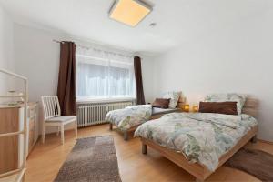 a bedroom with a bed and a chair and a window at Ferienwohungen Otto und Grete in Hemmoor