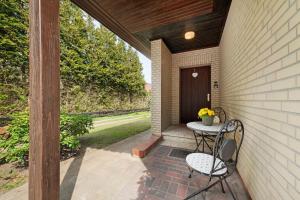 a patio with a table and a chair on a porch at Ferienwohungen Otto und Grete in Hemmoor