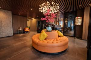 an orange ottoman in the middle of a lobby at Hotel Fogo Amsterdam in Amsterdam