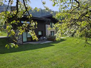 ein Haus mit einem grünen Vorgarten in der Unterkunft Quader Nidi nel Verde Authentic Farm Stay in the Italian Alps in Bienno
