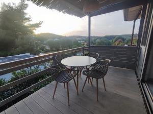 a patio with a table and chairs on a balcony at Agave by Aloe Residence Possidi in Possidi