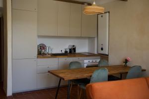 a kitchen with a wooden table and chairs at Vue Lac avec Terrasse Privée - "Lani" - Ola Verdon in Bauduen +20 photos
