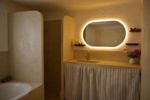 a bathroom with a tub and a sink and a mirror at Vue Lac avec Terrasse Privée - "Lani" - Ola Verdon in Bauduen
