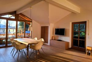 a dining room with a table and chairs and a television at Bodenschneidsuiten Luxburg in Tegernsee