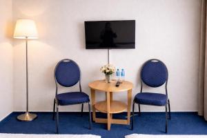a room with two chairs and a table and a tv at Hotel KM in Darmstadt +9 photos
