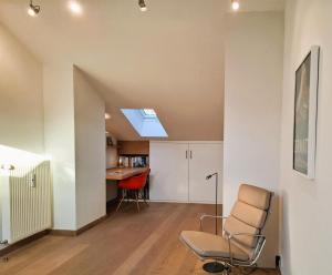 an attic living room with a skylight and a chair at Bodenschneidsuiten Luxburg in Tegernsee