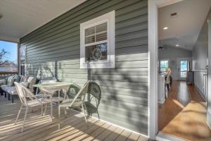 a deck with chairs and a table on a house at All Summer Long by Oak Island Accommodations in Oak Island