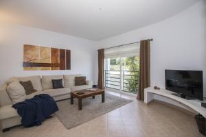 a living room with a couch and a tv at Casa Oliveira by Algarve Holidays in Loulé