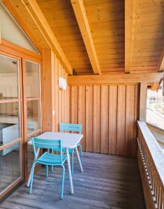 a wooden porch with a table and chairs on it at Bodenschneidsuiten Luxburg in Tegernsee