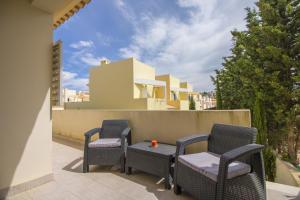 a patio with chairs and a table and a house at Casa Oliveira by Algarve Holidays in Loulé
