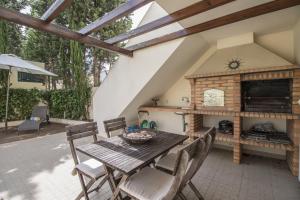 a patio with a wooden table and a fireplace at Casa Oliveira by Algarve Holidays in Loulé
