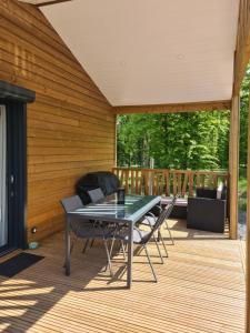 a patio with a table and chairs on a deck at Chalet Lac du Der Giffaumont-Champaubert in Giffaumont-Champaubert