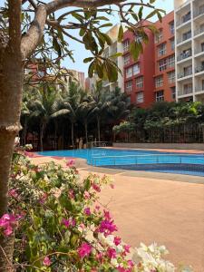 a resort with a swimming pool and some pink flowers at Platinum - Sun-kissed Holidays Goa in Dabolim