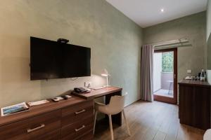 a room with a desk with a television on the wall at Quaint Boutique Hotel Sannat in Sannat